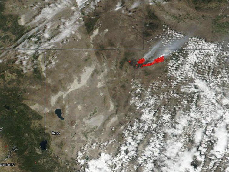 This July 8, 2018 satellite image from NASA's Suomi NPP satellite shows a wildfire, shown in red, also known as the Martin Fire, in Nevada, and smoke reaching to Idaho. 